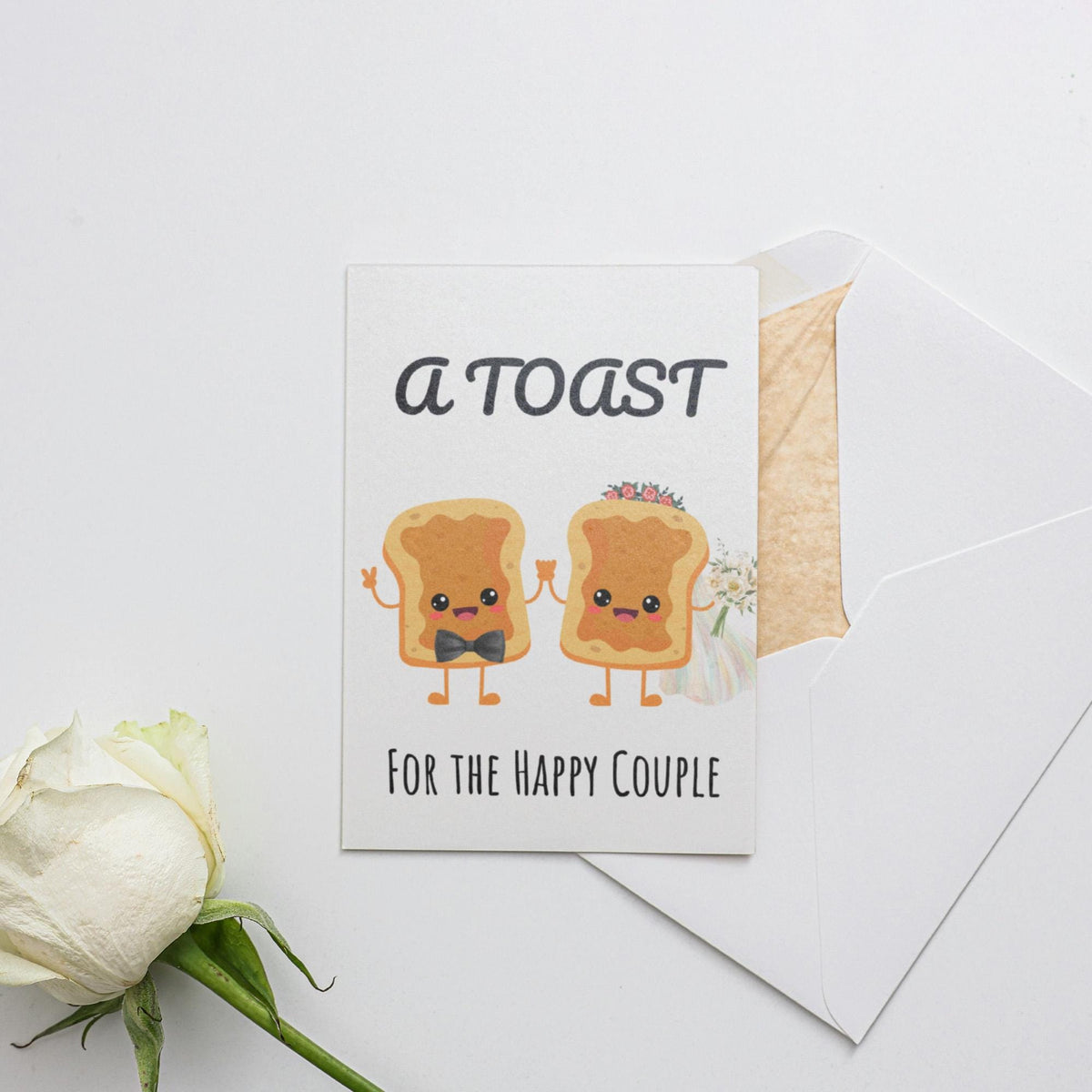 a white rose sitting next to a card with toast on it