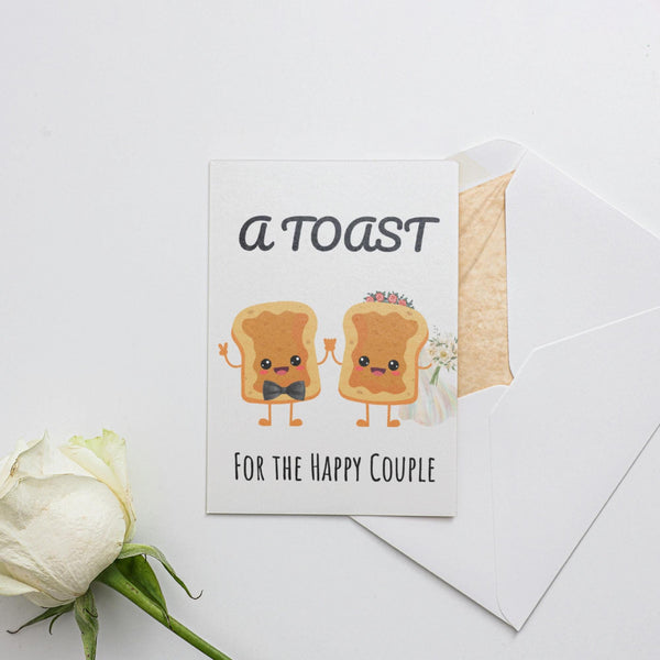 a white rose sitting next to a card with toast on it